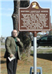 Man talking in front of the historical marker