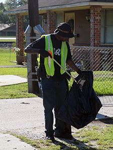 Man placing a piece of trash into a bag